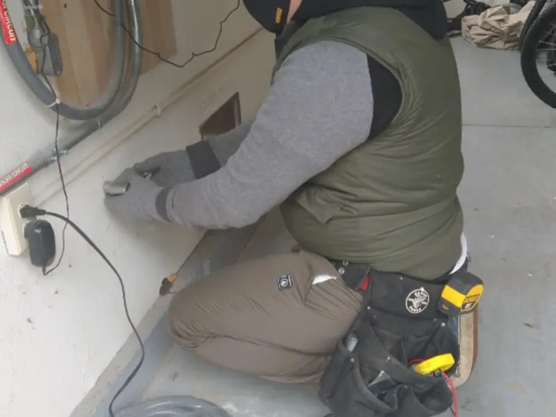 Electrician performing outlet wiring in a Wadena garage